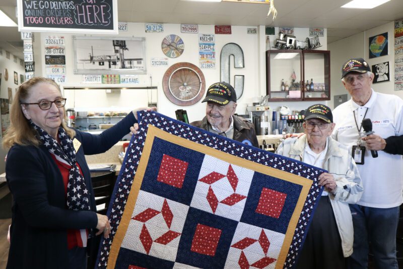 
Donna Kiger (L) presents Don Kuehl (CR) his "Quilt of Valor" at the Coffee 4 Vets gathering at Crazy Otto's Diner in Canyon Country, Calif., Thursday, Oct. 16, 2025. Kamryn Martell/The Signal