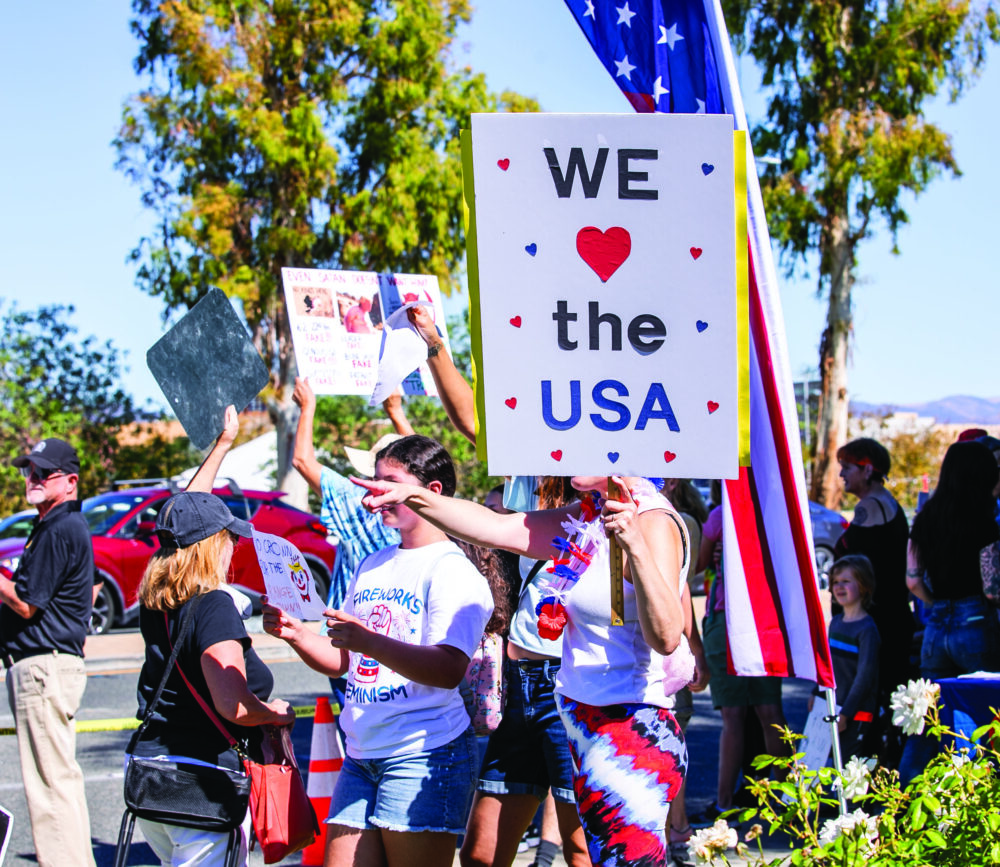 Residents gathered with custom-made signs during the "No Kings" protest at the intersection of Valencia Boulevard and McBean Parkway in Valencia on Saturday, Oct. 18, 2025. Habeba Mostafa/ The Signal