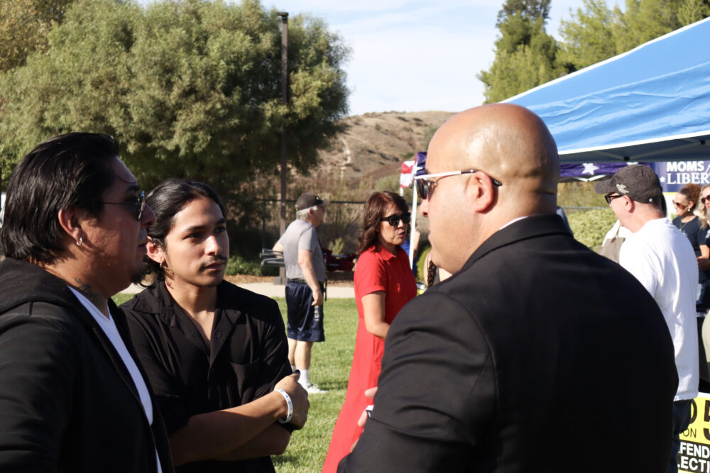 Ozie Sanchez (L), Joseph Sanchez (C) and Oscar Martinez (R), political candidate for Los Angeles County Sheriff's Department, speak with each other at the "Patriots in the Park" event at Circle J Ranch Park, Sunday, Oct. 19, 2025. Kamryn Martell/The Signal