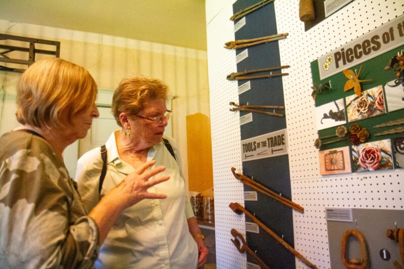 Canyon Questers Libby Hinze (left) and Deborah Harris take a close look at tools used by Carl Peters, a blacksmith who lived and worked at the Rancho Camulos Museum, and was honored through a new art exhibit on Oct. 11, 2025. Katherine Quezada/The Signal
