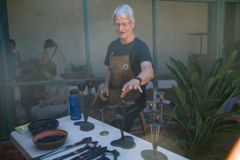 Blacksmith Gary Standke demonstrates the different tools Blacksmiths used to create everyday essentials and art pieces during the opening of “The Whimsical World of Carl Peters” on Oct. 11, 2025. Katherine Quezada/The Signal