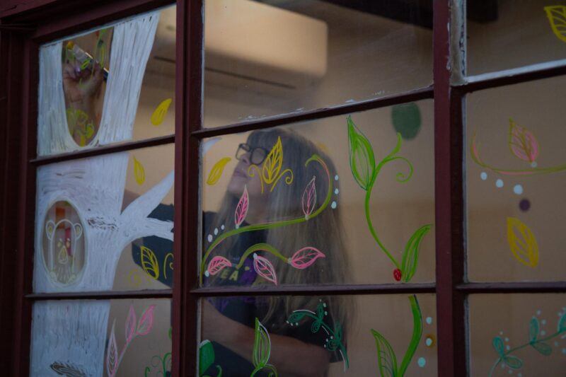 Silvia Sinlao, a volunteer for “Make A Difference Day” creates a fall-themed drawing on a large window of the  ARTree Community Arts Center on Oct. 25, 2025 in Newhall, Calif. Katherine Quezada/The Signal