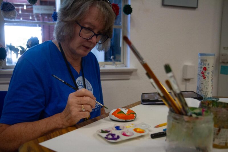 Sally Hoffman, volunteer and boardmember of ARTree Community Arts Center paints a rock to place as decorative pieces outside the center’s location for “Make a Difference Day” on Oct. 25, 2025 in Newhall, Calif. Katherine Quezada/The Signal