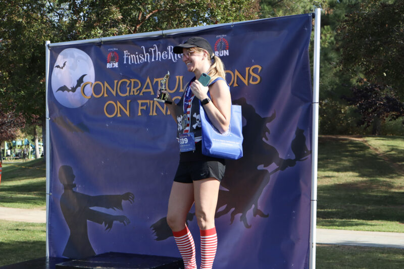 Tamra Savage shows off her trophy at the podium at the "Finish the Ride and Finish the Run" event at West Creek Park in Valencia, Calif., Sunday, Oct. 26, 2025. Kamryn Martell/The Signal