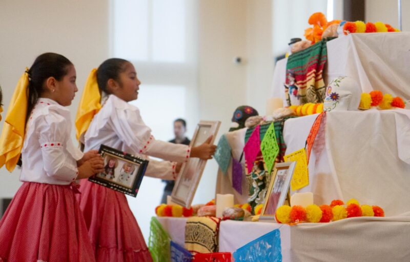 Children put photos up on display for the ofrenda during the Dia De Muertos celebration at the Canyon Country Community Center in Canyon Country on Oct. 25, 2025. Katherine Quezada/The Signal