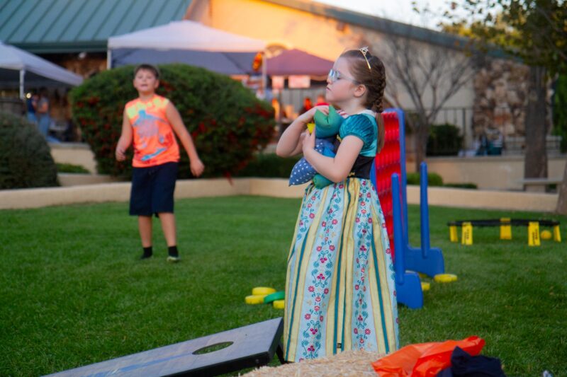 Olivia Arnone, 7, grabs bean bags to continue playing cornhole at the Church of the Canyos Fall Festival in Sand Canyon on Oct. 18, 2025. Katherine Quezada/The Signal