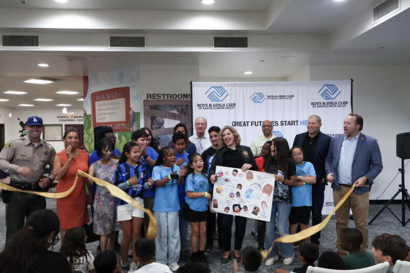 Assemblywoman Pilar Schiavo (C, holding poster board), D-Chatsworth, cuts the ribbon at the renovations ribbon cutting ceremony at the Boys and Girls Club of Santa Clarita Valley Thomas E. Dierckman Clubhouse in Canyon Country, Calif., Wednesday, Oct. 29, 2025. Kamryn Martell/The Signal