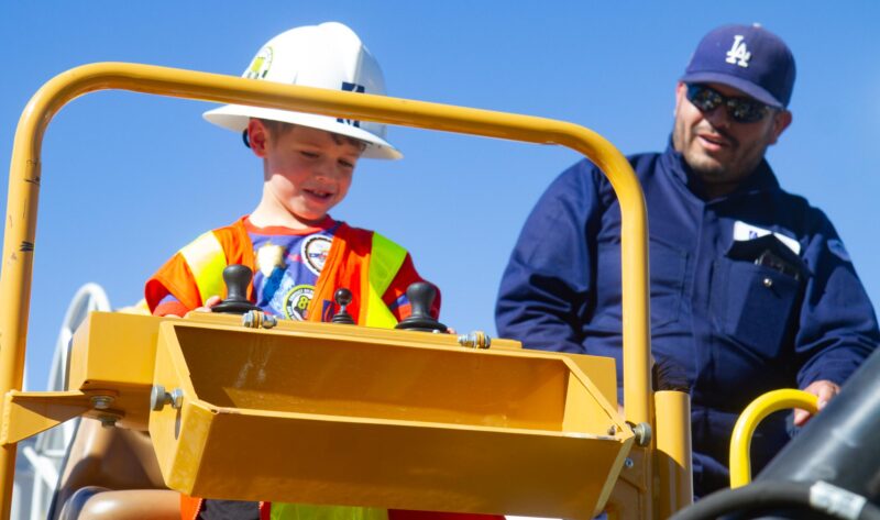 Drake Erwin ,4, explores a SoCalGas vehicle with the help of Energy Technician Ivan Moreno during the  fourth annual Touch-a-Truck hosted by the Santa Clarita Valley Education Foundation at Central Park in Saugus on Nov. 1, 2025. Katherine Quezada/The Signal