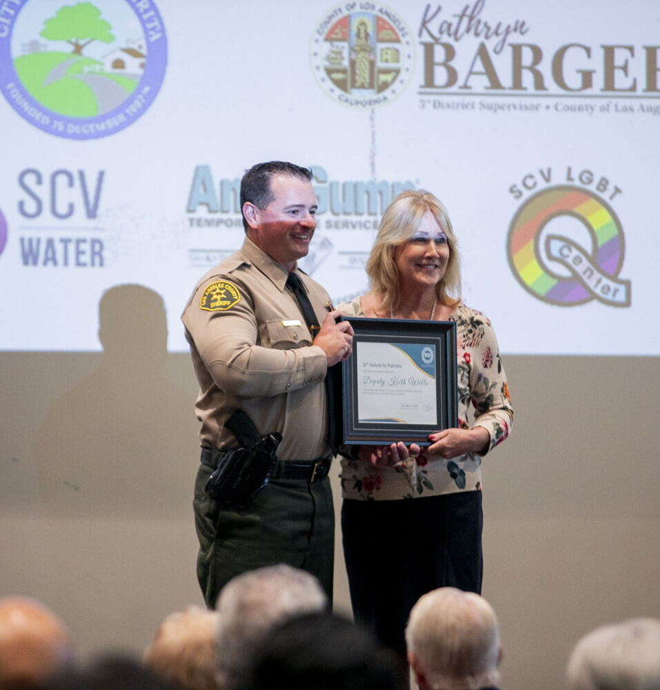 Santa Clarita Valley Sheriff's Deputy Keith Wells is recognized by Senior Field Deputy of 5th District Supervisor Kathryn Barger's Office Stephanie English during the SCV Chamber of Commerce's 15th annual "Salute to Patriots" event at Bella Vida on Wednesday, Nov. 5, 2025. Habeba Mostafa/ The Signal