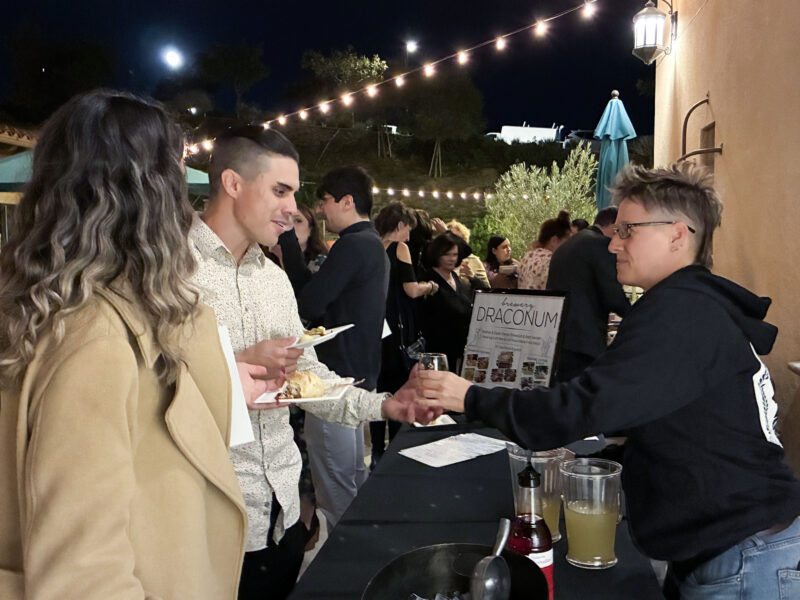Nadia Zaytoon (L) and Sean Herrera (C) grab drinks from Caroline Law (R) at the WiSH Foundation's "Wine Under the Roof" event at the Santa Clarita Valley Senior Center at Bella Vida in Canyon Country, Calif., Thursday, Nov. 6, 2025. Kamryn Martell/The Signal