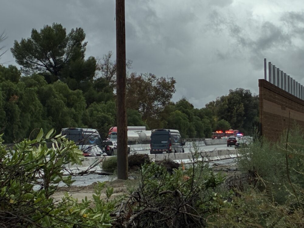 First responders were dispatched to a call about a big rig leaking diesel after a white SUV hydroplaned and hit it on Interstate 5 northbound Magic Mountain Parkway. Kamryn Martell/The Signal