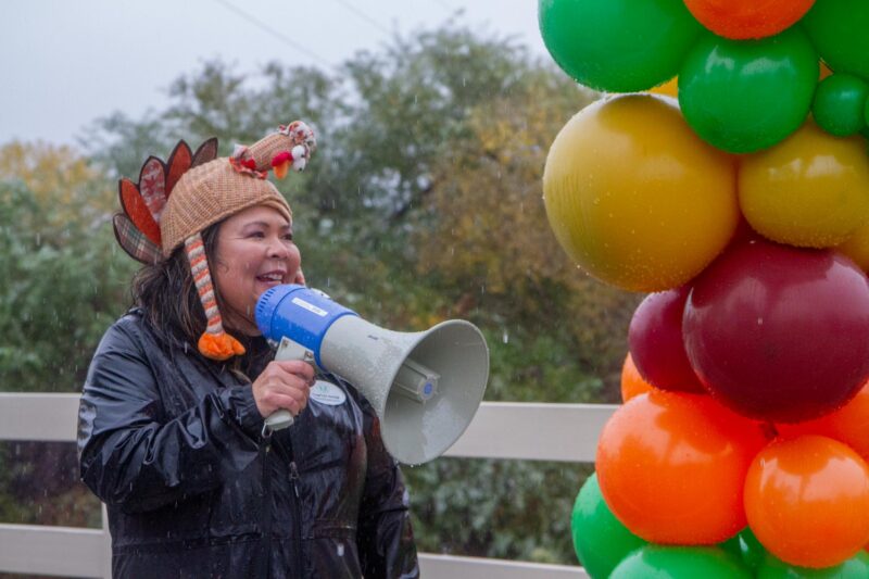 Bridge to Home Interim Executive Director Courtney Kanagi cheers on runners during the second annual Turkey Trot amid heavy rainfall in Valencia on Saturday, Nov. 15, 2025. Katherine Quezada/The Signal