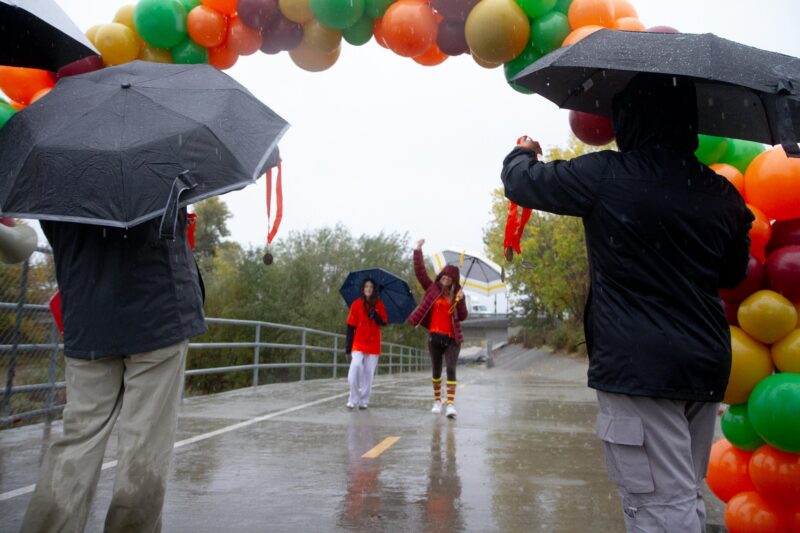Runners cheer at the finish line of Bridge to Home’s annual Turkey Trot  amid heavy rainfall in Valencia on Saturday, Nov. 15, 2025. Katherine Quezada/The Signal