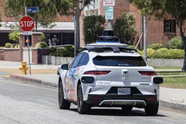 A self-driving Waymo vehicle awaits passengers in Los Angeles on July 1, 2025. Photo by John Fredricks.