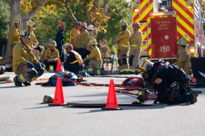 An official with the Los Angeles County Fire Department’s Urban Search & Rescue looks down through a sewer during a rescue operation to locate a dog on Monday, Nov. 24, 2025. Katherine Quezada/The Signal