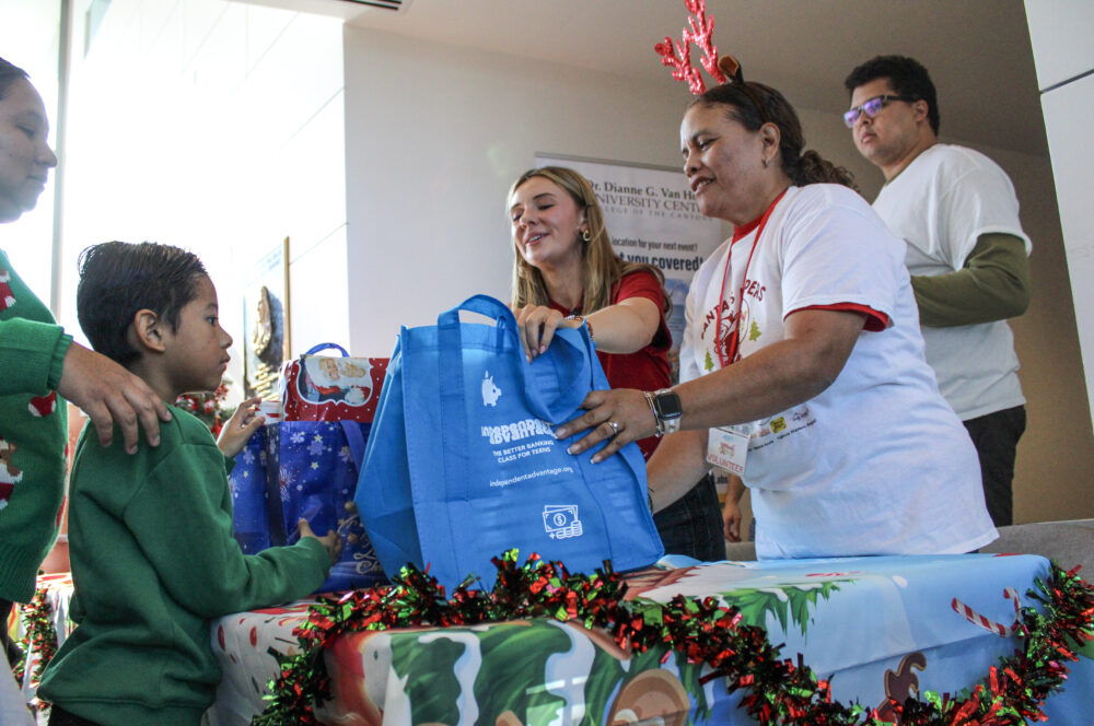JCI volunteers give a family their Christmas gifts during the JCI Santa's Helpers event on Saturday, Dec. 13, 2025. Susan Monaghan/The Signal