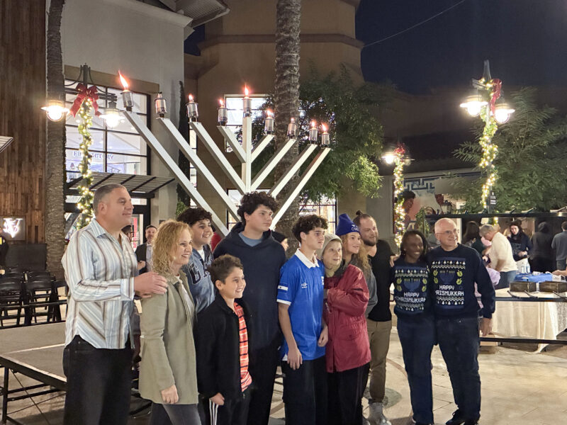 Attendees pose in front of the lit menorah at the Hanukkah at the Mall celebration at Westfield Valencia Town Center in Valencia, Calif., Sunday, Dec. 21, 2025. Kamryn Martell/The Signal