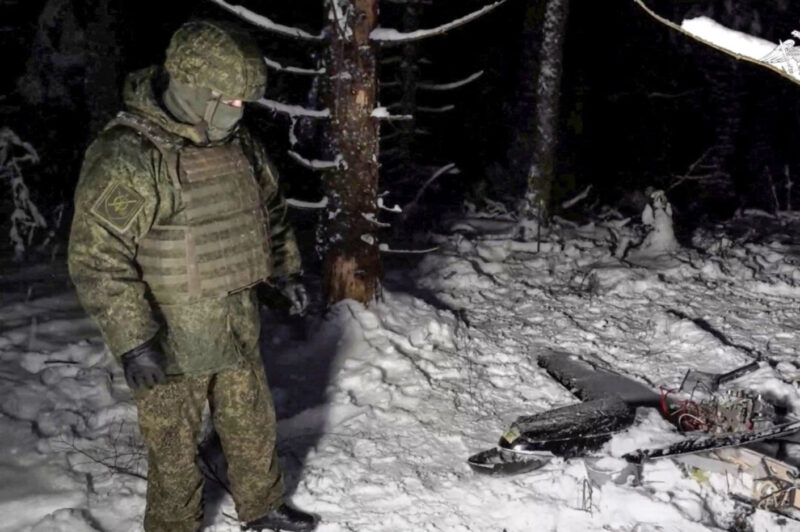 A Russian service member stands next to the remains of a drone, which, according to the Russian Defence Ministry, was downed during the repelling of an alleged Ukrainian attack on the Russian presidential residence in the Novgorod Region, in an unknown location in Russia, in this still image from a video released December 31, 2025. Russian Defence Ministry/Handout via Reuters