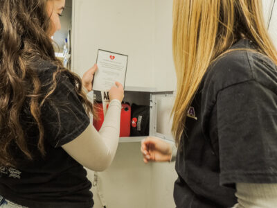 Nessa Santistevan (L) and Lucy Elderd (R) install the AED at Santa Clarita Valley Food Pantry. Photo courtesy of Nessa Santistevan.