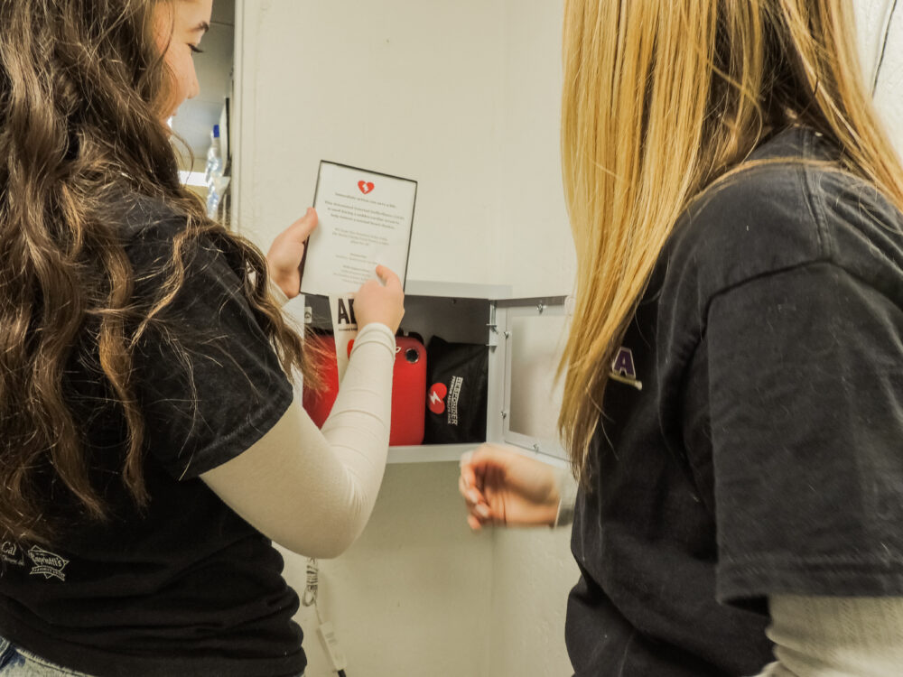 Nessa Santistevan (L) and Lucy Elderd (R) install the AED at Santa Clarita Valley Food Pantry. Photo courtesy of Nessa Santistevan.