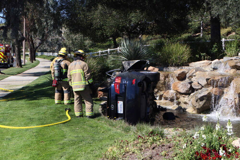 Los Angeles Fire Department personnel assess the Lexus in the fountain after a traffic collision resulted in a vehicle fire on Avenida Rancho Tesoro and Copper Hill Drive, Monday, March 2, 2026. Kamryn Martell/The Signal