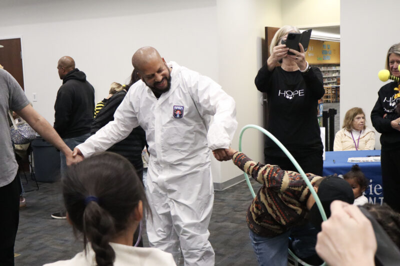 Steven Binns (left, white space suit) helps a child with the hula hoop exercise at the 5th annual Hope Theatre Arts event at the Canyon Country Jo Anne Darcy Library in Canyon Country, Calif., Sunday, March 8, 2026. Kamryn Martell/The Signal