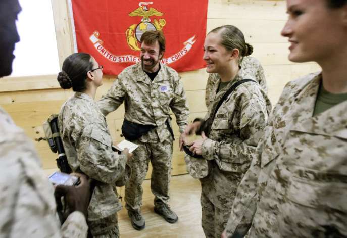 U.S. Marines and sailors from the California-based Regimental Combat Team 7 meet action-movie star Chuck Norris, at Al Asad air base in Al Anbar Province, West of Baghdad, on Oct. 31, 2006. IM GOODWIN/USMC/AFP via Getty Images