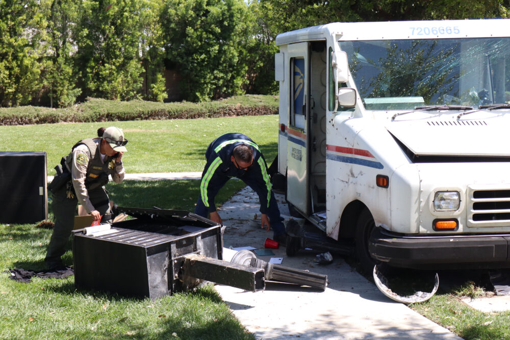 Santa Clarita Valley Sheriff's Station deputies and tow truck personnel grab mail from a broken mailbox and the mail truck on Prima Way and Propello Drive in Canyon Country, Monday, April 6, 2026. Kamryn Martell/The Signal