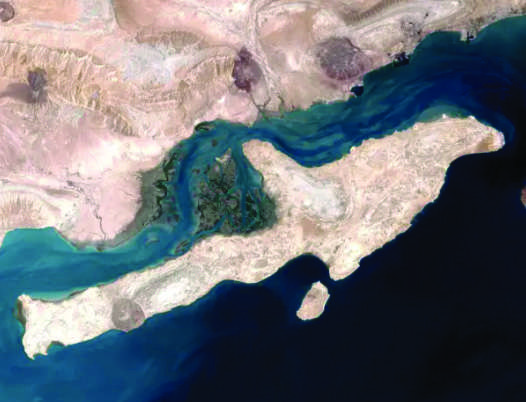 Analysts say that seizing Qeshm Island at the mouth of the Strait of Hormuz could weaken Iran’s ability to disrupt maritime traffic. The island is seen here in a satellite image on Aug. 23, 2000. (NASA)