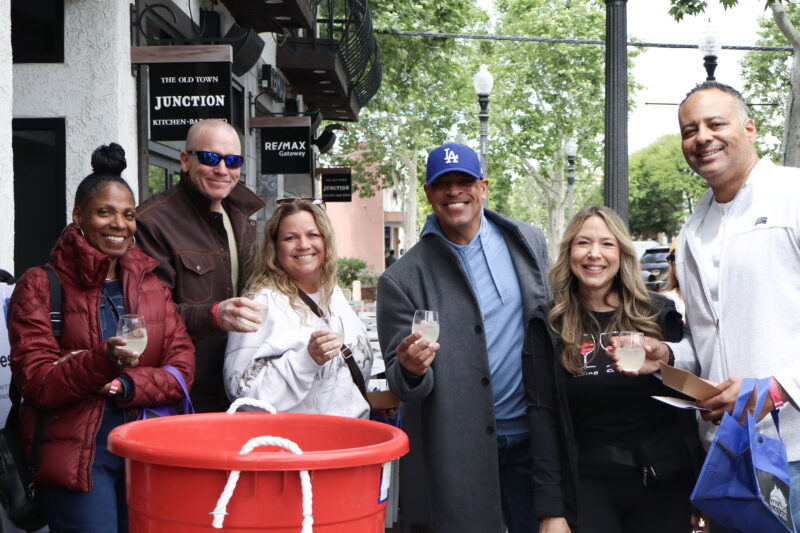 The Scott Family and Schauble Family smile for a photo at the Sidecar Market/Old Town Junction booth at the Soroptimist International of Greater Santa Clarita Valley's 17th annual "Wine Affair: Sip, Savor, Stroll" in Newhall, Calif., Sunday, April 12, 2026. Kamryn Martell/The Signal
