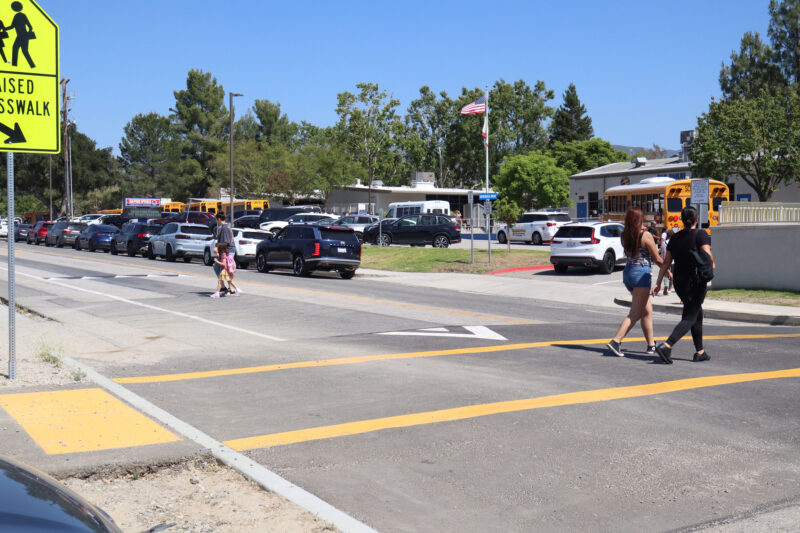 People jaywalk or cross the street with the crosswalk during school pickup at Sulphur Springs Community School in Canyon Country, Calif., Thursday, May 21, 2026. Kamryn Martell/The Signal