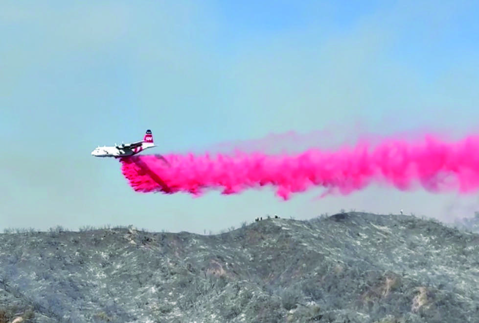 A fixed-wing aircraft makes a drop of Phos-Chek fire retardant on the Max Fire in Stevenson Ranch on Monday, June 15, 2026. Signal staff photo.
