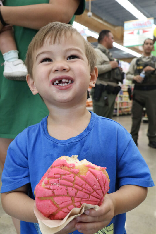 Luke C., 2 1/2, smiles with his concha at the Santa Clarita Valley Sheriff's Station's "Conchas with a Cop" at Vallarta Supermarket in Canyon Country, Calif., Tuesday, June 16, 2026. Kamryn Martell/The Signal