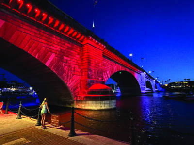 A woman marvels at the red light illuminating the 1831 London Bridge in Lake Havasu City, Ariz., on June 5, 2026. Photo by Allan Stein.