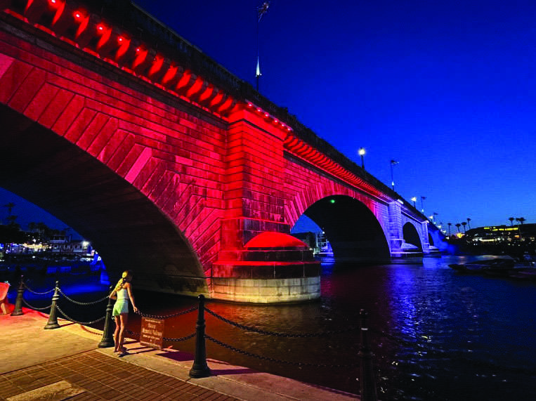 A woman marvels at the red light illuminating the 1831 London Bridge in Lake Havasu City, Ariz., on June 5, 2026. Photo by Allan Stein.