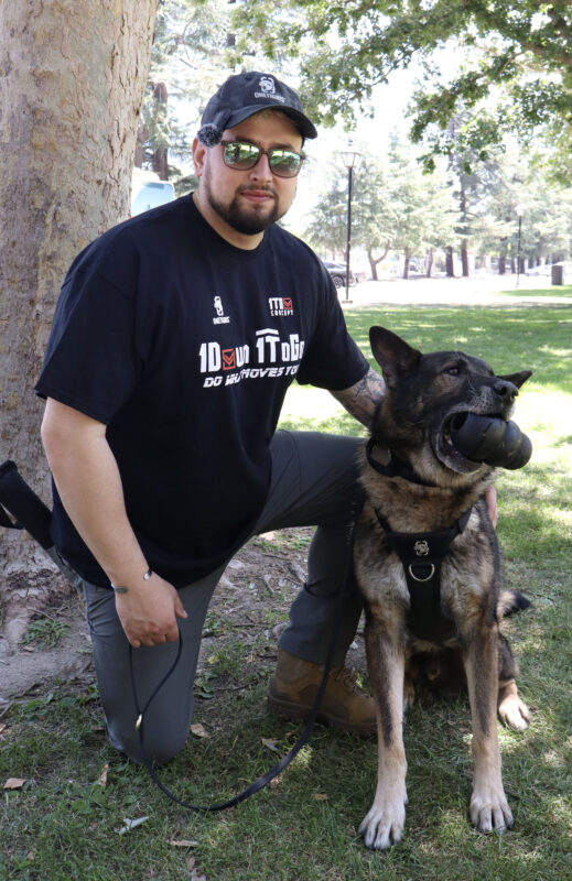 Tyler McCoy, the owner and handler of Arlo, poses with Arlo, a retired K-9, at the "Picnic with the Pack: K-9 Arlo is Back!" event at Hart Park in Newhall, Calif., Monday, June 22, 2026. Kamryn Martell/The Signal