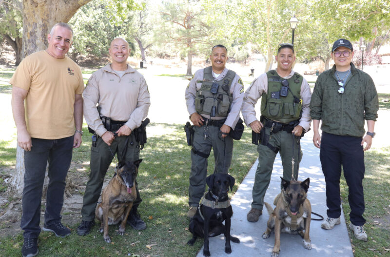OneTigris Tactical and Dog Gear and Los Angeles County Sheriff's Department smile for a photo at the "Picnic with the Pack: K-9 Arlo is Back!" event at Hart Park in Newhall, Calif., Monday, June 22, 2026. Kamryn Martell/The Signal