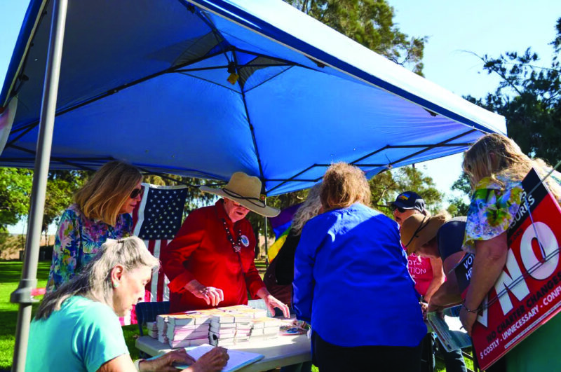 Protect Huntington Beach volunteers hand out campaign materials in Huntington Beach on Nov. 11, 2023. Photo by Lauren Justice for CalMatters
