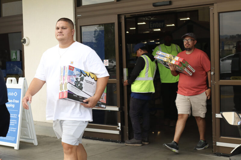 People walk out of Sam's Club with multiple Pokémon boxes in Canyon Country, Calif., Tuesday, June 21, 2026. Kamryn Martell/The Signal