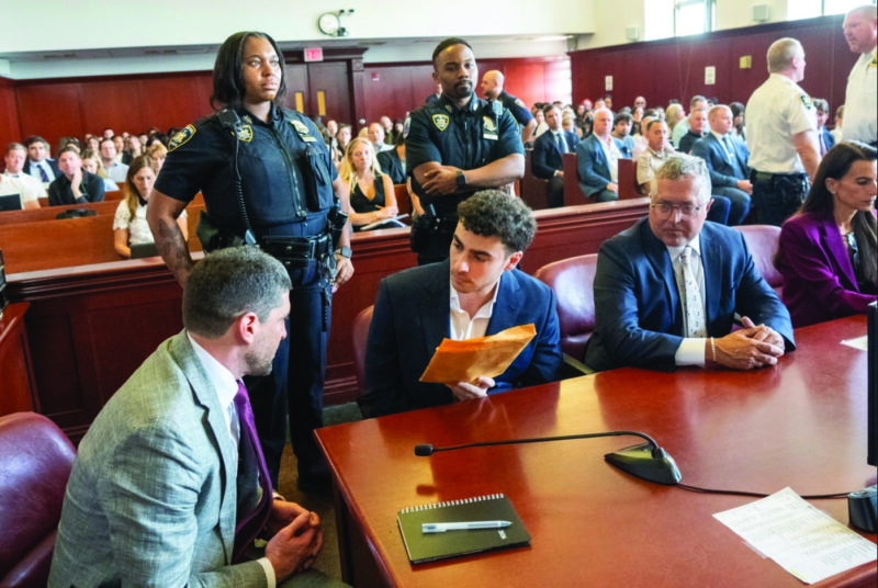 Luigi Mangione (C) speaks with his attorney Jacob Kaplan (L) as he appears in Manhattan Supreme Court in New York City on June 17, 2026. Steven Hirsch/Pool/Getty Images
