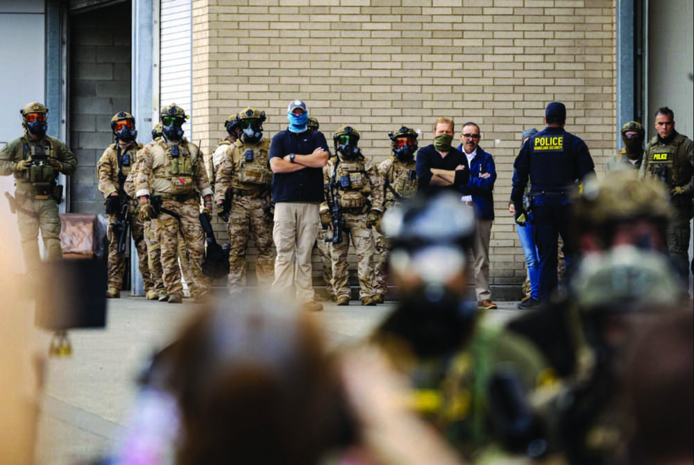 Federal agents monitor protesters in front of Immigration and Customs Enforcement offices in Portland, Ore., on Oct. 4, 2025. Photo by John Fredricks.