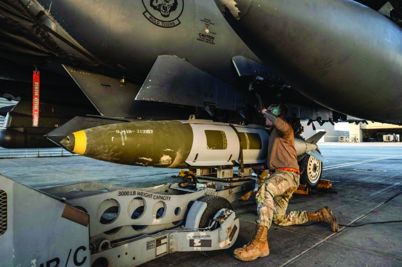 A U.S. Airman attaches a GBU-31 munitions system to an F-15E Strike Eagle in the U.S. Central Command area of responsibility, in an undisclosed location, on Dec. 18. U.S. Air Force via Getty Images
