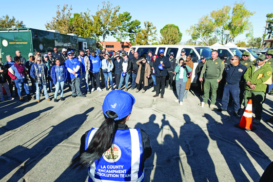 Los Angeles County Sheriff's Department Homeless Outreach Services Team (HOST) deputies, pictured at right, participate in a multidisciplinary team briefing before a homeless encampment operation in the Antelope Valley in November 2024. (Photo credit: Diandra Jay/Los Angeles County)