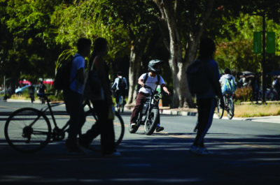 Students walk and ride electric bicycles on campus at the University of California, Davis on Oct. 3, 2023. Photo by Miguel Gutierrez Jr., CalMatters