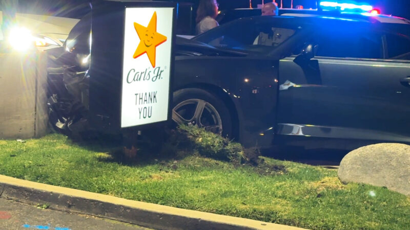The grey Camaro pushed into the Carl's Jr. Signage, both suffering damage at Carl's Jr parking lot/sidewalk located on Newhall Ave and Sierra Highway, Calif., Tuesday, Oct, 20, 2026. Signal Staff/The Signal.