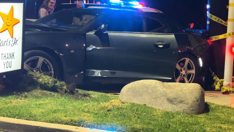 The grey Camaro pushed into the Carl's Jr. Signage, both suffering damage at Carl's Jr parking lot/sidewalk located on Newhall Ave and Sierra Highway, Calif., Tuesday, Oct, 20, 2026. Signal Staff/The Signal.