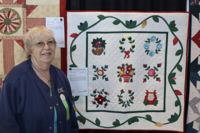 Barbara Montejo smiles next to her decades-long project at the Santa Clarita Valley Quilt Guild's quilt show at the SCV Senior Center at Bella Vida, Sunday, Oct. 25, 2026. Kamryn Martell/The Signal