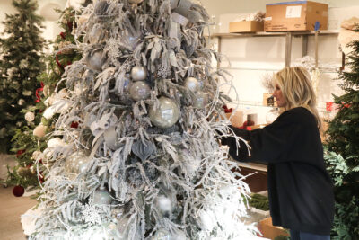 Kristin Dervin, lead designer of Festival of Trees, attaches ornaments to her Polar Bear/Winter Wonderland tree at Valencia Town Center in Valencia, Calif., Monday, Oct. 26, 2026. Kamryn Martell/The Signal